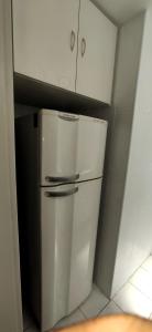 a small kitchen with a white refrigerator and cabinets at Economical Hosting Downtown - Hospedagem econômica no centro de Campinas in Campinas
