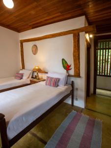 two beds in a room with wooden ceilings at Pousada Santa Martha in Ubatuba