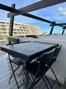 une table et des chaises assises sur un balcon dans l'établissement AphrodiX Village naturiste, au Cap d'Agde