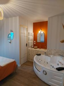 a large bathroom with a tub and a bed at Au Clair De Lune in Pléneuf-Val-André