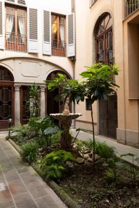 a garden in front of a building with a fountain at Pied-a-terre Cappelle Medicee in Florence