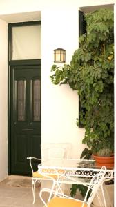 a green door with a table and chairs in front of it at ZOE in Keramoto +11 photos