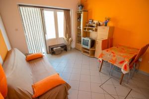 a room with two beds and a table and a television at Apartments Meri - 1 in Lopar