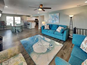 a living room with a blue couch and a kitchen at Frisco- Flats in Rockport