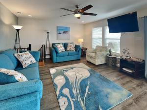 a living room with two blue couches and a fan at Frisco- Flats in Rockport