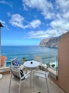 ein Balkon mit Tisch und Stühlen und Blick auf das Meer in der Unterkunft Apartamento incleibles vistas al océano y piscina. in Acantilado de los Gigantes + 57 Fotos