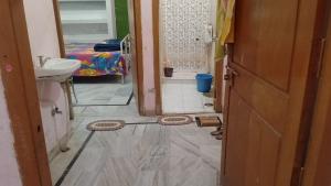 a bathroom with a sink and a toilet in a room at Kumbh Home Stay in Jhūsi