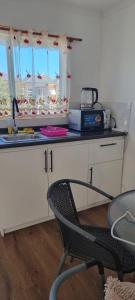 a kitchen with a counter and a chair in a room at Cabaña central a pasos del terminal in Valdivia