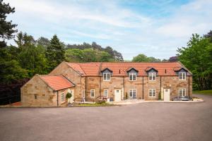 a large stone house with red roof at Sandsend Retreats at Saltmoore in Sandsend