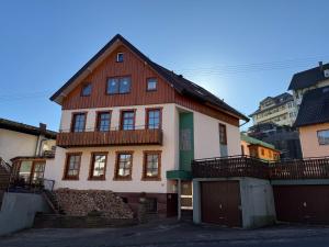 a brown and white house with a fence at Wildneschd - Zentral & Schwarzwald Plus inklusive in Bad Wildbad