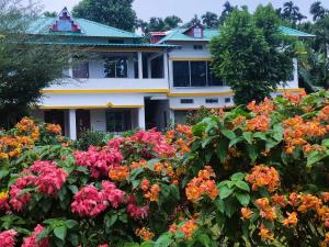 a garden of flowers in front of a house at Chander Pahar Homestay in Rājābhāt Khāwa