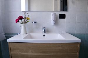 a bathroom sink with a vase of flowers on it at Mi Casa Affittacamere in Osio Sotto +41 photos