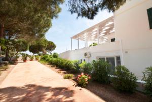 a driveway leading to the side of a white building at Hotel Garden Salento in Torre Vado