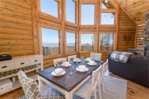 una sala da pranzo con tavolo e sedie in una cabina di A-Frame Cabin with Long Range Mountain Views a Banner Elk