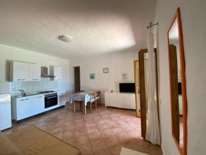 a kitchen and a living room with a table at Appartamenti Cala d'Ambra in San Teodoro