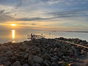 a person standing on a pier near the water at Charming House by the Sea with Beautiful Garden in Glommen