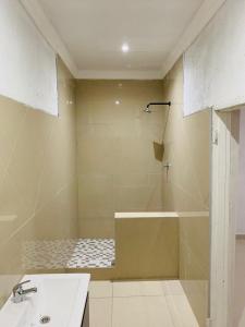 a bathroom with a shower and a sink and a tub at Rooibok Gardens in Mokopane