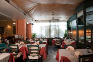 un restaurante con mesas y sillas con manteles rojos en Hotel Il Cavaliere Nero, en Tirrenia