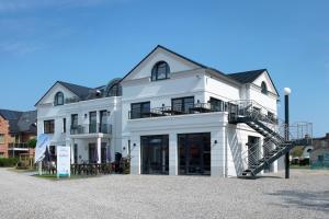 a white house with a spiral staircase in front of it at Aparthotel Museumshof in Fehmarn