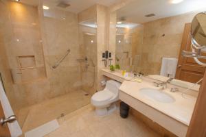 a bathroom with a toilet and a shower and a sink at Hotel Dann Carlton Cali in Cali