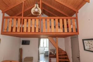 a loft bed in a living room with a wooden ceiling at Sternes house in Stérnai