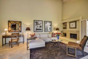 a living room with a white couch and a fireplace at Elegant Lakeside Villa in Rancho Mirage