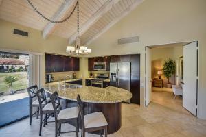a kitchen with a large island with chairs around it at Elegant Lakeside Villa in Rancho Mirage