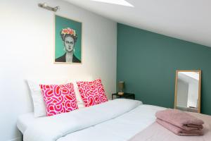a bedroom with a white bed with colorful pillows at L'Odéon - Hypercentre - Gare SNCF in Nantes
