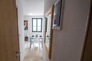 uma sala de estar com uma mesa e uma televisão na parede em Apartments Umag Center em Umag