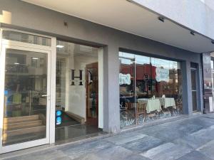 a store front with glass doors and a table at Hotel Olavarria in Olavarría