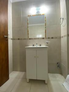 a bathroom with a white sink and a mirror at Hotel Olavarria in Olavarría