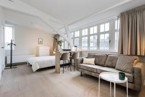 a living room with a couch and a bed at City Apartments Nijmegen in Nijmegen