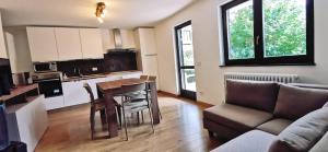 a kitchen and living room with a table and a couch at Casa Cermis in Cavalese