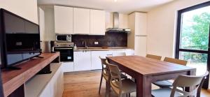 a kitchen with a wooden table and white cabinets at Casa Cermis in Cavalese +32 photos