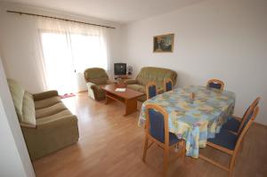 a living room with a table and chairs and a couch at Apartment Djuka in Njivice