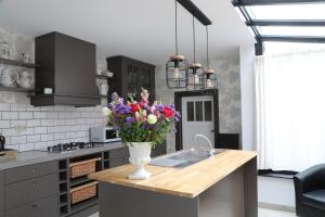 a kitchen with a vase of flowers on a counter at Gastenkamers Boussemaere in Ichtegem