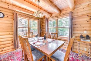 una sala da pranzo con tavolo, sedie e orologio di Lakefront Corinth Log Home Private Dock, Fire Pit a Lake Luzerne
