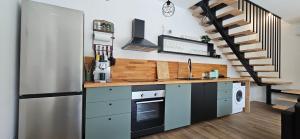 a kitchen with a stainless steel refrigerator and a staircase at Aparthouse with pool in Solin