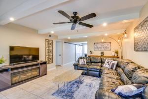 a living room with a couch and a flat screen tv at Golf, Shop and Hike Youngtown Hideaway! in Youngtown
