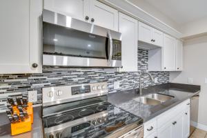 a kitchen with white cabinets and a stainless steel stove at Golf, Shop and Hike Youngtown Hideaway! in Youngtown