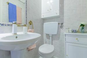 ein weißes Badezimmer mit Toilette und Waschbecken in der Unterkunft Seixal Yachting Bay Vintage in Seixal