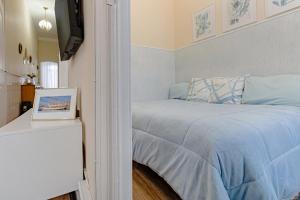 Schlafzimmer mit einem Bett mit blauer Bettwäsche und einem TV in der Unterkunft Seixal Yachting Bay Vintage in Seixal + 58 Fotos