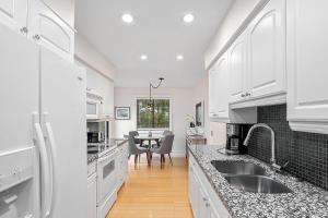 une cuisine blanche avec un évier et une table dans l'établissement Main Stay Cottage, à Saugatuck