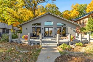 a gray house with a porch and a patio at How you Dune in Saugatuck