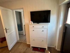 a dresser with a flat screen tv on top of it at Haus Sonnenschein in Zingst in Zingst