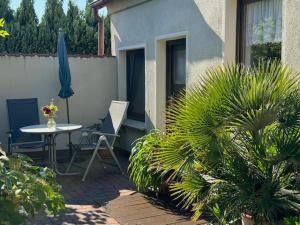 a patio with a table and a chair and an umbrella at Haus Sonnenschein in Zingst in Zingst