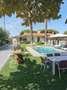 a table and chairs next to a swimming pool at villa eri in Kalamákion