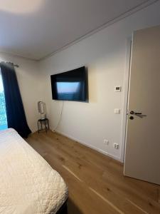 a bedroom with a bed and a flat screen tv on the wall at Luxury Apartment,close to city in Örebro