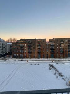 a snow covered parking lot in front of a building at Luxury Apartment,close to city in Örebro