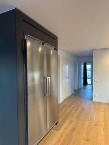 a large stainless steel refrigerator in a living room at Luxury Apartment,close to city in Örebro